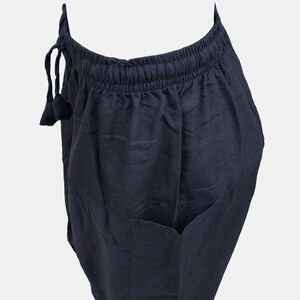 May include: Black drawstring pants with a single pocket on the right side.