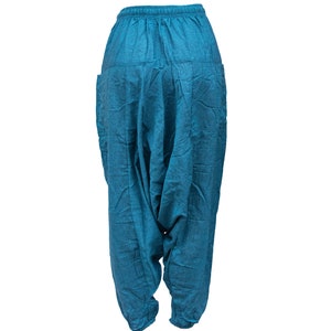 May include: Teal blue cotton pants with a loose, baggy fit and a drawstring waist.