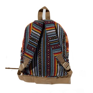 May include: A multi-colored striped backpack with a brown strap and buckle. The backpack is made of woven fabric and has a geometric pattern.