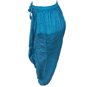 May include: Teal blue cotton pants with a drawstring waist and a single pocket on the side.