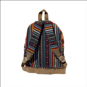 May include: A multi-colored striped backpack with brown straps and buckles. The backpack is made of woven fabric with a geometric pattern.