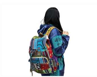 May include: A multi-colored patchwork backpack with a blue, green, red, yellow, and orange design. The backpack has a flap with a zipper closure and a drawstring closure. The backpack is being worn by a person with long black hair.