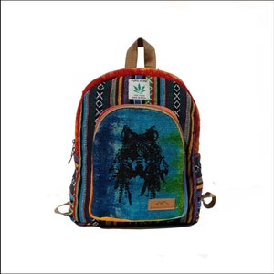 May include: A multi-colored hemp backpack with a wolf design on the front pocket. The backpack has a brown leather strap and a label that says "PURE HEMP THE FREE WORLD MADE IN NEPAL".