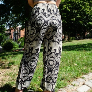 May include: Black and white patterned pants with an elephant design. The pants are loose fitting and have a wide leg.
