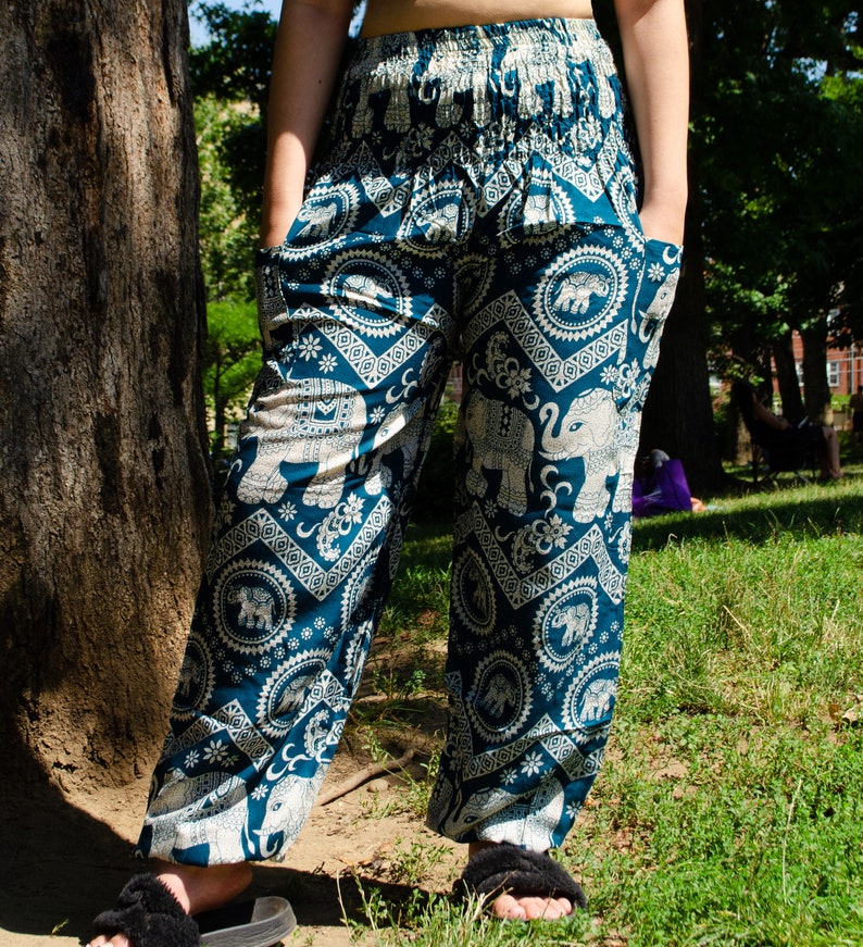 May include: Blue and white patterned pants with an elephant design. The pants have a wide leg and a drawstring waist.