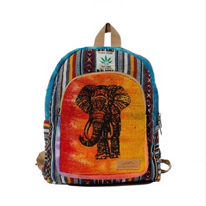 May include: A multi-colored hemp backpack with an elephant design on the front. The backpack has a zipper closure and a small pocket on the front. The backpack is made of hemp and has a tag that says "Pure Hemp" and "THC Free".