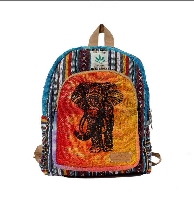 May include: A multi-colored hemp backpack with an elephant design on the front. The backpack has a zipper closure and a small pocket on the front. The backpack is made of hemp and has a tag that says "Pure Hemp" and "THC Free".