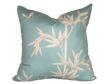 May include: A blue throw pillow with a white bamboo and butterfly design.