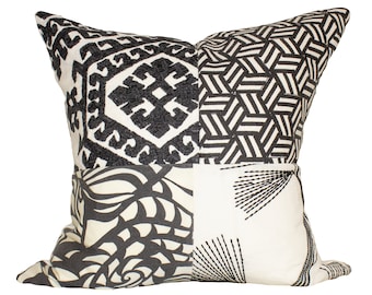 May include: Square decorative pillow with a patchwork design. The pillow features four distinct sections with black and white patterns, including geometric shapes and abstract designs. The pillow is likely made of a soft fabric.