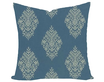 May include: A blue throw pillow with a white embroidered pattern of repeating diamond shapes. The pillow is made of a soft, textured fabric.