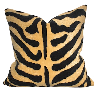 May include: A square cushion with a zebra stripe design in black and tan. The cushion has a soft, velvety texture. This decorative cushion is designed for home decor and measures approximately 45cm x 45cm.