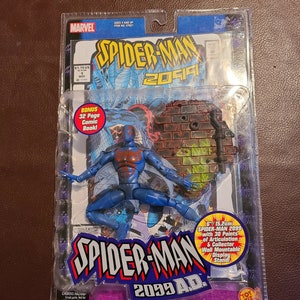 May include: A blue and red Spider-Man 2099 action figure with 30 points of articulation. The figure is packaged in a plastic blister pack with a comic book and a wall mountable display stand. The packaging features the Marvel logo and the text "Spider-Man 2099 A.D."