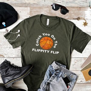 May include: A green t-shirt with the text "Catch You On The Flippity Flip" and a basketball graphic.