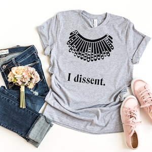 May include: A gray t-shirt with a black silhouette of a collar and the text "I dissent."