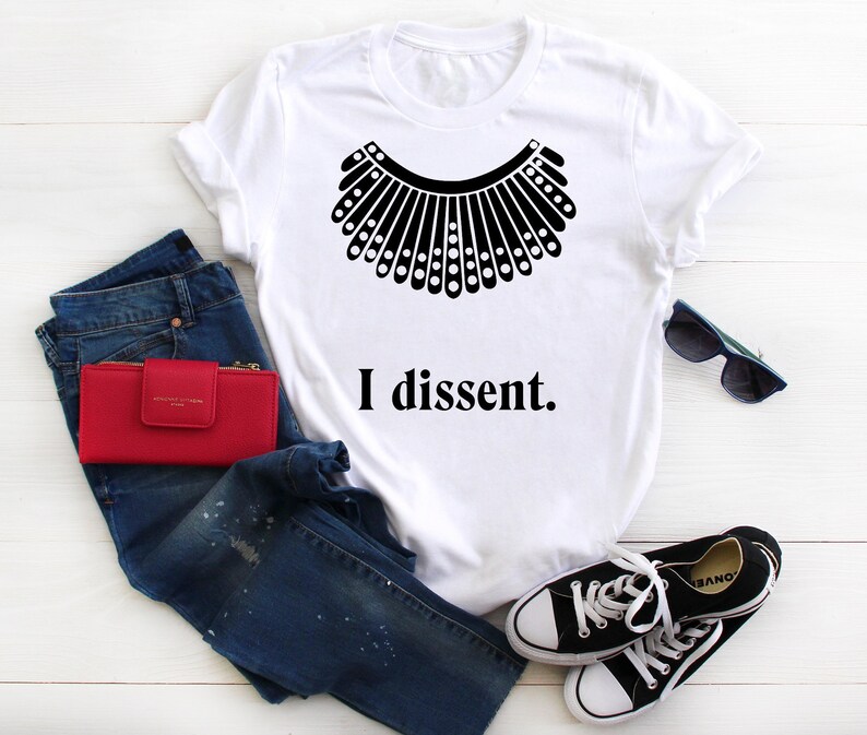 May include: White t-shirt with a black silhouette of a judge's collar and the text "I dissent."