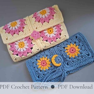 May include: Two rectangular crochet pouches featuring floral granny square motifs. One pouch is cream with pink and yellow flowers, while the other is blue with yellow and pink flowers and a small yellow crescent moon accent on the front surface.