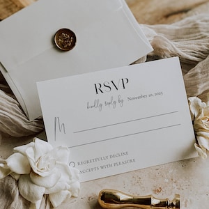 May include: White RSVP card with black text. The text reads "RSVP kindly reply by November 10, 2025". There are two options to choose from: "Regretfully Decline" or "Accepts with Pleasure".