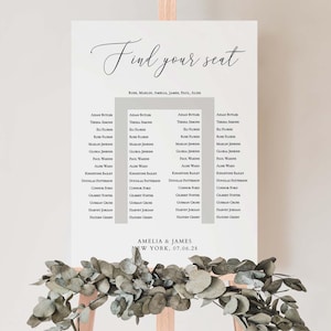 May include: A white seating chart with the words "Find your seat" in elegant script. The chart lists names in columns, with the names "Amelia & James" and the date "07.06.28" at the bottom. The chart is displayed on a wooden easel.