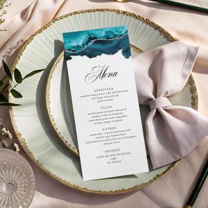 May include: A vertical menu card featuring a teal and white agate-inspired design with silver glitter accents at the top. The text includes sections for Appetizer, Salad, Entree, and Dessert, printed in a black serif font on a white background.
