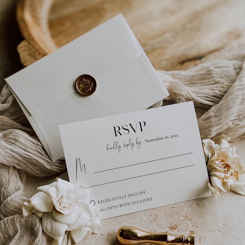 May include: White RSVP card with black text. The text reads "RSVP kindly reply by November 10, 2025". There are two options to choose from: "Regretfully Decline" or "Accepts with Pleasure".