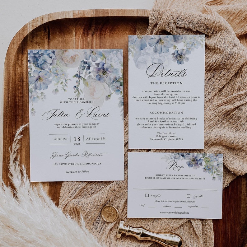 Puede incluir: Un conjunto de invitaciones de boda con un dise&ntilde;o floral de acuarela en tonos azules. La invitaci&oacute;n presenta los nombres "Julia & Lucas" y detalles sobre su ceremonia de boda y su recepci&oacute;n en el restaurante Grew Garden. La tarjeta RSVP incluye una secci&oacute;n para que los invitados indiquen su preferencia de comida.