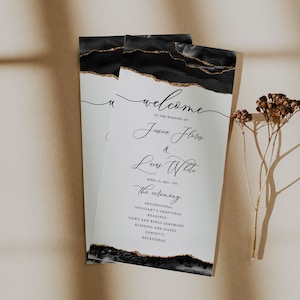 May include: Wedding ceremony program with black and gold abstract design. The program includes the names of the couple, Jessica Flores and Lucas White, the date of the wedding, April 15, 2021, and the location, NY. The program also includes the order of the ceremony.