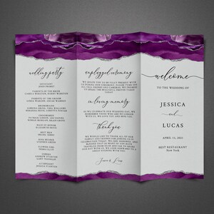 May include: A purple and silver wedding programme with a watercolour background. The programme includes the wedding party, ceremony details, and a welcome message for Jessica and Lucas. The wedding is on 15 April 2021 at Best Restaurant in New York.