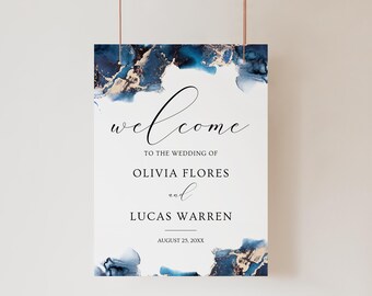 May include: A white wedding welcome sign with blue and gold watercolor accents. The text reads "Welcome to the wedding of Olivia Flores and Lucas Warren August 25, 20XX".