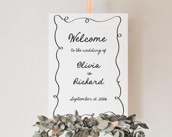 May include: White wedding welcome sign with a black decorative border. The sign reads "Welcome to the wedding of Olivia & Richard September 15, 2026".