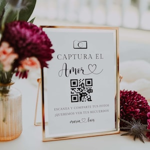 May include: A framed sign with gold trim and the words "CAPTURA EL AMOR" in black script. Below is a QR code and text that reads "ESCANEA Y COMPARTE TUS FOTOS ¡QUEREMOS VER TUS RECUERDOS maria luis".