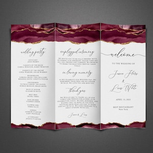 Könnte beinhalten: Ein dreiteiliges Hochzeitsprogramm mit einem burgunderfarbenen Aquarellhintergrund und goldenen Glitzerakzenten. Das Programm enthält die Hochzeitsgesellschaft, die Zeremoniedetails und eine Willkommensnachricht für die Hochzeit von Jessica Flores und Lucas White. Die Hochzeit ist für den 15. April 2021 im Best Restaurant in New York geplant.