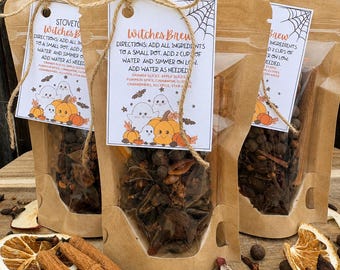 May include: Three brown paper pouches filled with dried spices, each featuring a white tag labeled Witches Brew with instructions to add two cups of water and simmer. The tags display illustrations of ghosts, pumpkins, and spiderwebs.