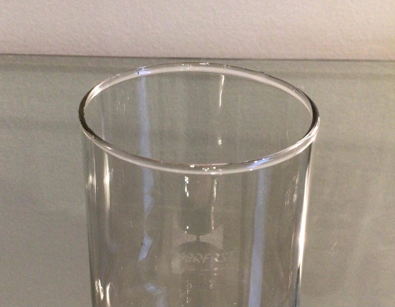 May include: A clear glass drinking glass with a wide mouth and a straight, cylindrical shape.