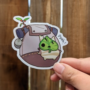 May include: A sticker featuring a cartoon character with a leaf-shaped face and a backpack. The character is light brown and green, with a small plant on top of the backpack. The text "pyah!" is next to the character.