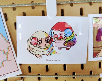 May include: A print featuring two cartoon characters: a sheep and a clown. The sheep is white with pink horns and a rainbow-colored mane. The clown has a red hat, a white face, and a rainbow-colored wig. The text "@waifuarts" is at the bottom.