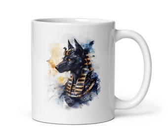 May include: White ceramic coffee mug with a watercolor illustration of an Anubis jackal wearing a gold pharaoh's headdress.