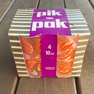 May include: A box of four 10-ounce orange juice glasses with a citrus design. The box is green and white striped with a purple label that says "pik-pak" and "Made in Canada".