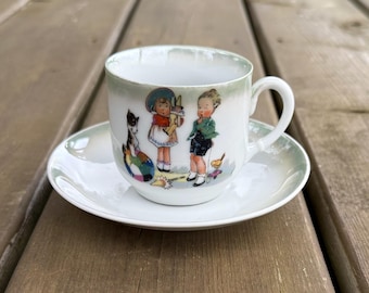 Juego de taza de té y platillo de porcelana bávara antigua con niños y perros, fabricado en Alemania.
