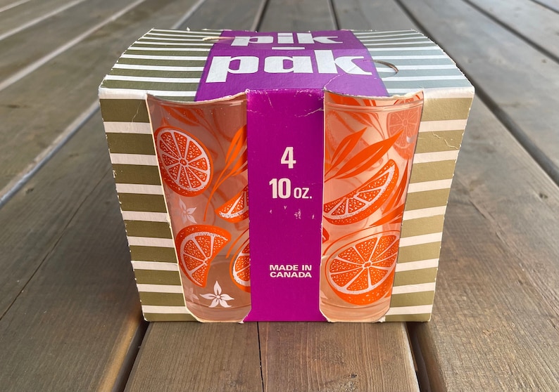 May include: A box of four 10-ounce orange-patterned drinking glasses. The box is striped brown and white and says "Pik-Pak" in pink letters. The box also says "4 10 oz. Made in Canada".