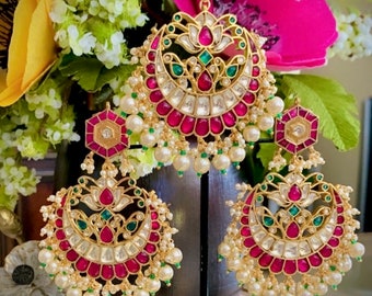 May include: A set of gold-toned earrings and a pendant necklace with pink and green gemstones, white pearls, and intricate floral designs.