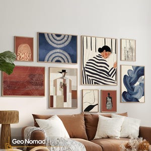 Può includere: Una composizione a parete con otto stampe artistiche incorniciate di varie dimensioni. La collezione include motivi geometrici astratti, una figura con camicia a righe, una persona con cappello e forme blu vorticose, in cornici di legno chiaro.