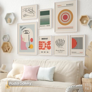 May include: A gallery wall set featuring seven framed art prints with abstract, geometric, and line-art designs in muted tones. The collection includes Bauhaus-themed posters, a Matisse-inspired tree illustration, and a stylized face graphic.