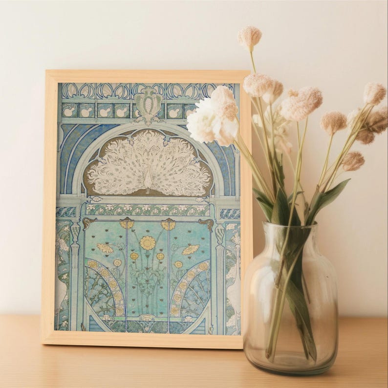 May include: A rectangular light wood frame containing a print with a blue and white illustration of a peacock with a fanned tail, positioned above stylized floral patterns. Next to the frame is a clear glass vase holding several dried flowers.
