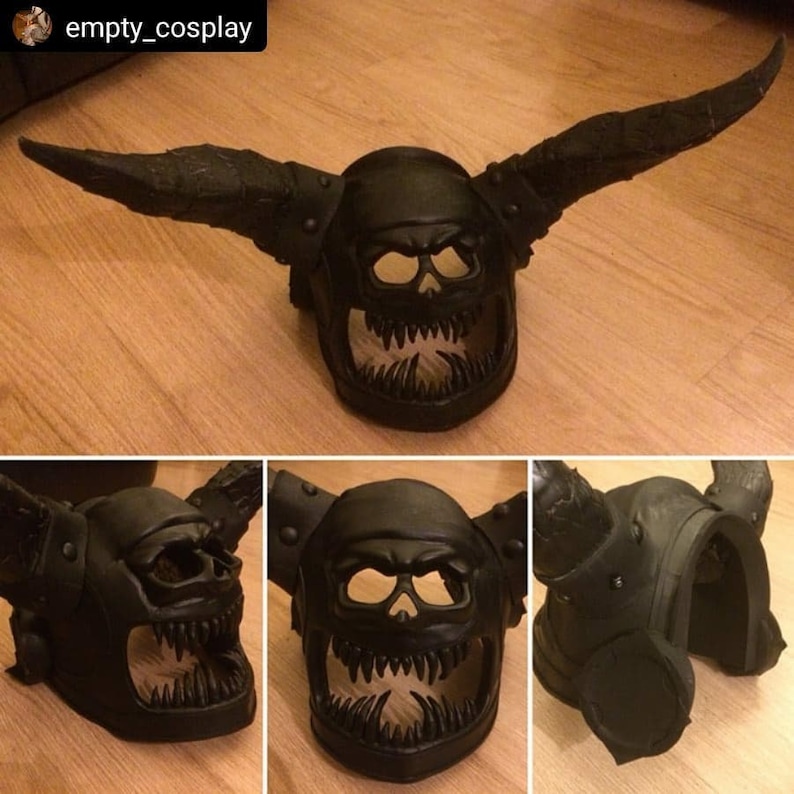 Pu&ograve; includere: Un casco di plastica nero con corna e un viso a forma di teschio. Il casco ha un design dettagliato con punte e un ghigno pieno di denti.