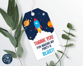 May include: A 2 x 3.5 inch editable favor tag with a rocket ship, planets, and stars on a dark blue background. The text on the tag reads "Thank you for making my party a blast!"