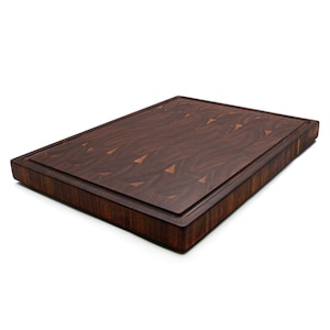 A wooden cutting board with a dark brown, textured surface.