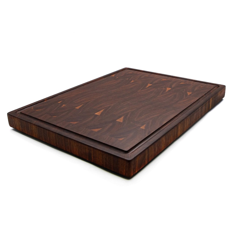 A wooden cutting board with a dark brown, textured surface.