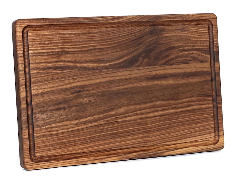 A wooden cutting board with a natural wood grain texture and visible grain lines.