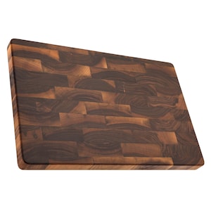 A wooden cutting board with a dark brown, natural wood grain pattern.