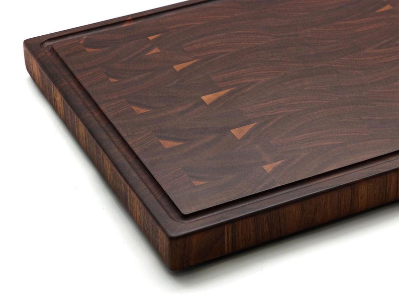 A wooden cutting board with a dark brown, textured surface.